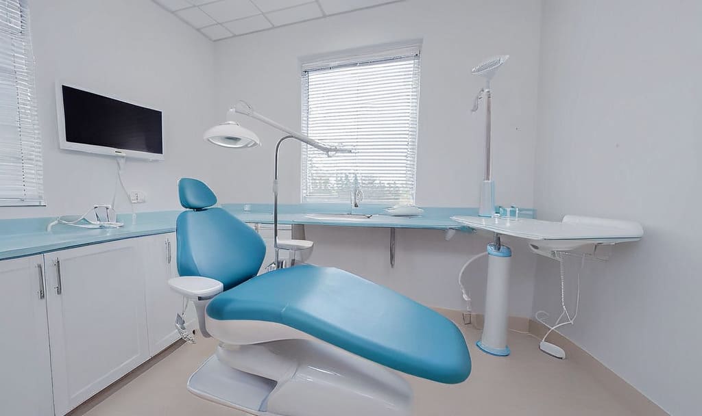 Nowoczesny gabinet stomatologiczny z fotelem dentystycznym przygotowanym do zabiegów profilaktycznych, takich jak fluoryzacja zębów.